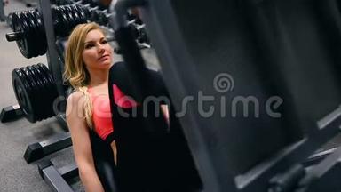 年轻<strong>女子</strong>在健身房的机器出<strong>版</strong>社工作。 在健身房的模拟器里锻炼的西班牙黑人美女